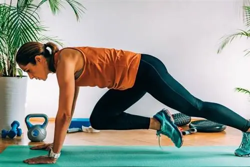 Женщина делает упражнение на коврике