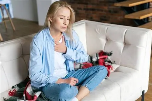 Женщина держится за грудину