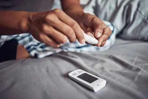 Мужчина измеряет уровень сахара глюкометром