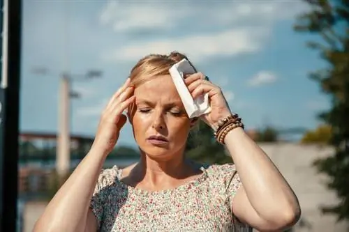 Молодая женщина страдает от сильной головной боли.