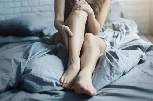 Крупный план ног молодой женщины в постели.