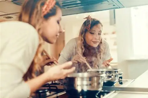 Молодая женщина готовит на кухне.