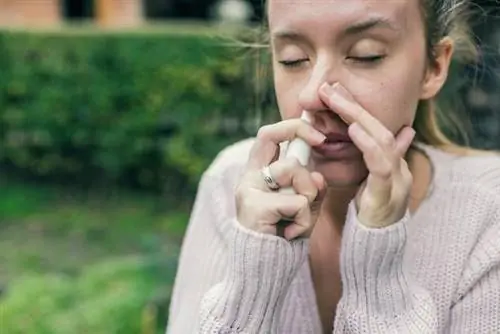 Женщина использует назальный спрей