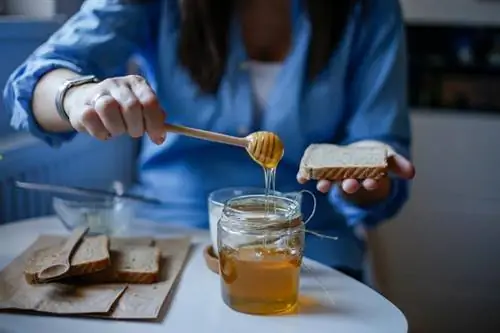 Женщина мажет бутерброд медом