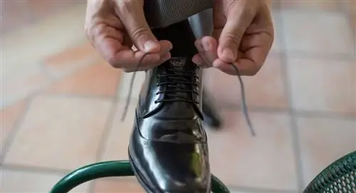 мужчина завязывает шнурки