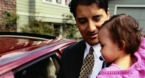 отец с ребенком на руках собирается на работу