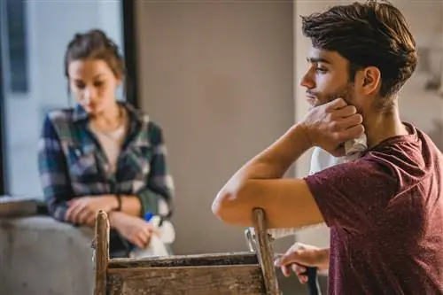 Обеспокоенная пара думает о проблемах с ремонтом квартиры.