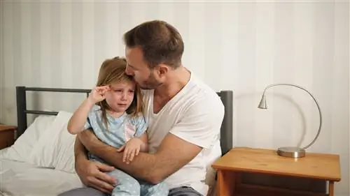 Отец утешает свою расстроенную и грустную дочь в помещении