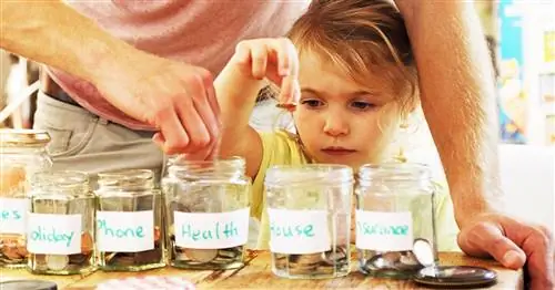 ребенок кладет монетки в копилку