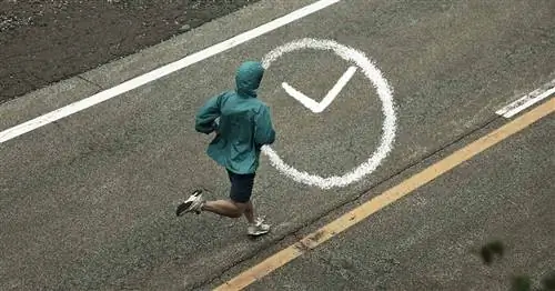 Кто-то бежит по улице в синей куртке по серому асфальту