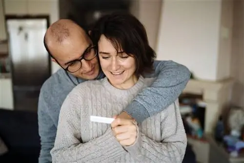 Мужчина и женщина смотрят дома на тест на беременность.