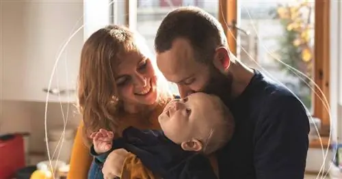 мужчина и жена с любовью смотрят на ребенка, которого держат на руках