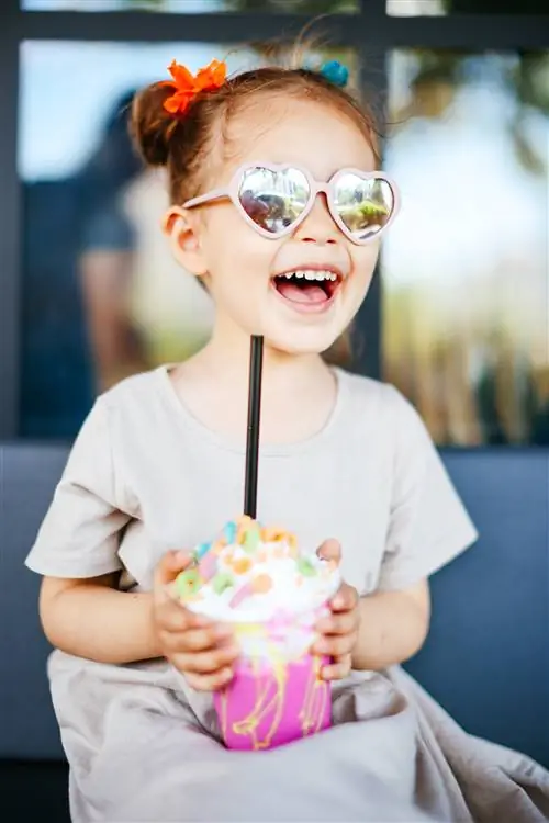 Розовый клубничный коктейль со сладостями, взбитые сливки в кафе, экстремальный молочный коктейль