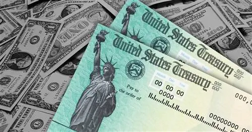 два стимулирующих чека сидят на куче наличных