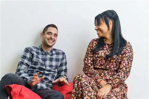 Два сотрудника разных национальностей разговаривают и веселятся после работы