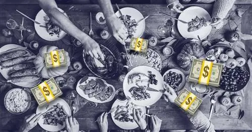 Черно-белое фото обеденного стола на День Благодарения с золотыми анимированными стопками денег с долларовыми си…