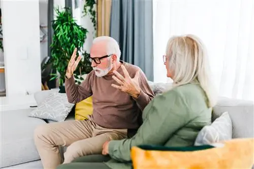 Старшие гетеросексуальные пары ссорятся, сидя дома на диване.