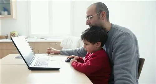 отец и сын с помощью ноутбука