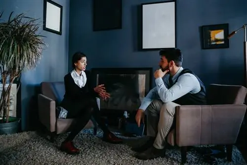 Мужчина разговаривает с терапевтом в ее кабинете.