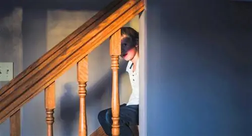 наказанный ребенок сидит на лестнице