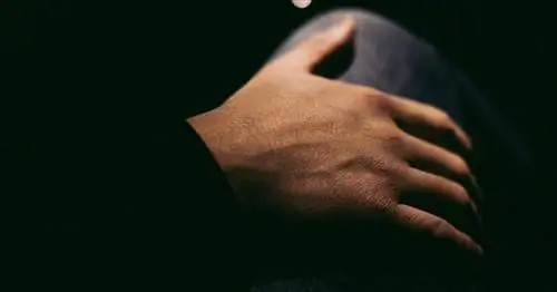 крупный план мужской руки, окруженной тенью