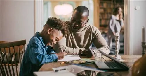 Папа помогает сыну делать уроки.