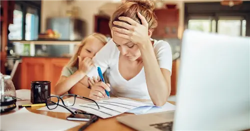 Мать-одиночка работает дома с дочерью в одной комнате.