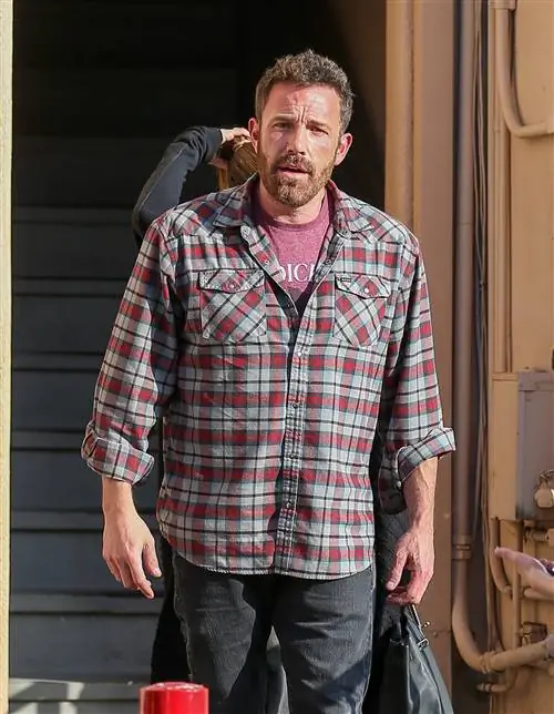 Бен Аффлек в клетчатой рубашке и джинсах.