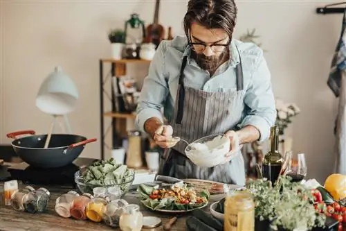 Мужчина готовит блюдо, соответствующее средиземноморской диете.