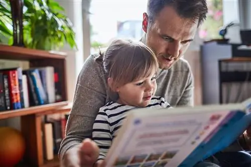 Папа читает книгу со своей маленькой дочерью.