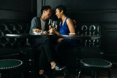 Пара пьет в кабинке, задавая забавные вопросы, чтобы помочь узнать больше о своем партнере.