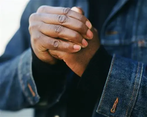 Крупный план человека, хрустящего костяшками пальцев.