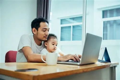 Азиатский отец и его сын используют портативный компьютер у себя дома в воскресенье или в праздник.