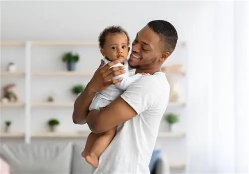 отец и дитя. Счастливый молодой черный папа обнимает милого маленького мальчика, пока они вместе позируют в…