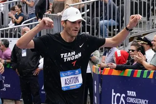 Эштон Катчер празднует, пересекая финишную черту во время Нью-Йоркского марафона 2022 года в Северной…