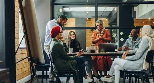 Счастливые бизнесмены весело улыбаются во время встречи в творческом офисе.