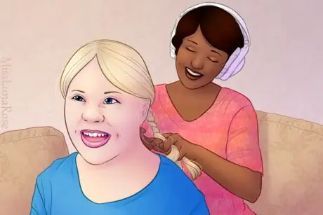 Девушка заплетает волосы подруге с синдромом Дауна