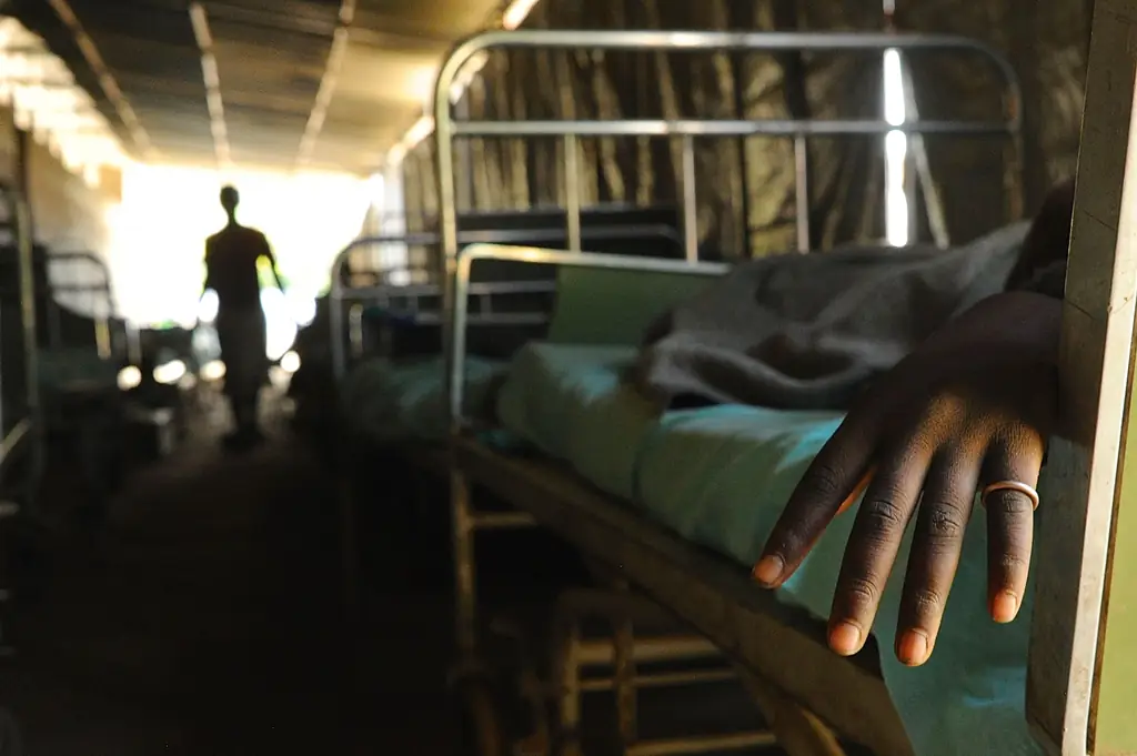 Больной лежит в постели у Матери Милосердия