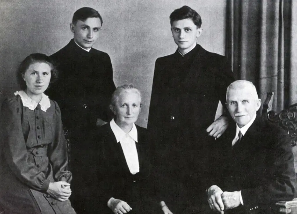 На снимке, сделанном в 1951 году, изображена семья Йозефа Ратцингера (вверху справа) во Фрайзинге, Бавария, после рукоположения его самого и его брата Георга (вверху слева). Кардинал Германии Йозеф Ратцингер был избран 265-м Папой Римско-католической церкви 19 апреля 2005 года и принял имя Бенедикт XVI. Нижний ряд: его сестра Мария, его мать Мария и его отец Йозеф